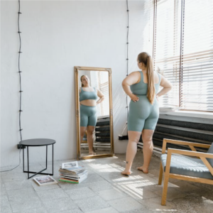 woman standing in front of mirror in workout clothes